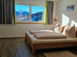 - une chambre avec un lit en face d'une fenêtre dans l'établissement Cozy holiday apartment in the Salzburger Land, à Wagrain