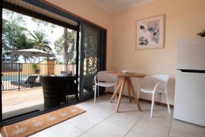 a kitchen with a table and a refrigerator at Latitude 17 - Suite 1 in South Mission Beach