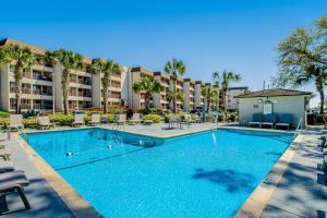 a swimming pool with chairs and a hotel at HH Beach & Tennis F11 in Hilton Head Island