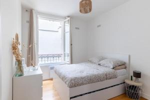 ein weißes Schlafzimmer mit einem Bett und einem Fenster in der Unterkunft BOULOGNE-PORTE D'AUTEUIL ROLAND GARROS TOURISME in Boulogne-Billancourt