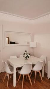 ein weißes Esszimmer mit einem weißen Tisch und Stühlen in der Unterkunft BOULOGNE-PORTE D'AUTEUIL ROLAND GARROS TOURISME in Boulogne-Billancourt