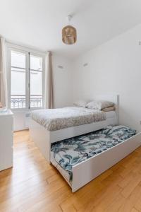 ein weißes Schlafzimmer mit 2 Betten in einem Zimmer in der Unterkunft BOULOGNE-PORTE D'AUTEUIL ROLAND GARROS TOURISME in Boulogne-Billancourt