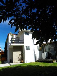 a white building with a garage in a yard at Casa Fresnos in Amealco