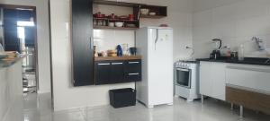 a kitchen with a refrigerator and a stove at Pousada Recanto Boituva in Boituva