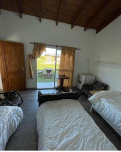 - une chambre avec 2 lits et une fenêtre dans l'établissement Posada La Martina, à Goya