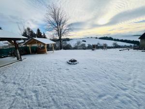 a yard covered in snow with a gazebo at Chalupa LUPA in Liptovská Kokava