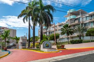 a street in front of a building with palm trees at Tropical Villa Ocean View in Maunabo