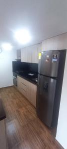 a kitchen with a stainless steel refrigerator and wooden floors at Apartamento de Lujo Sabaneta Jacuzzi in Sabaneta