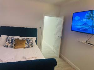 een slaapkamer met een bed en een flatscreen-tv bij Newly Refurbished 1Bedroom 4 mins walk to Crystal Palace Station in Crystal Palace