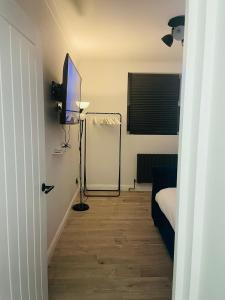 Cette petite chambre comprend une télévision et un lit. dans l'établissement Newly Refurbished 1Bedroom 4 mins walk to Crystal Palace Station, à Crystal Palace