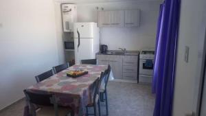 a kitchen with a table and a white refrigerator at Complejo El Descanso in San Antonio Este