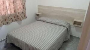 a small bed in a corner of a room at Complejo El Descanso in San Antonio Este +2 photos
