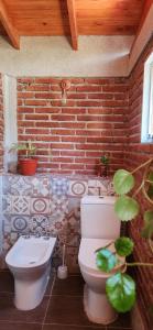 baño con aseo y pared de ladrillo en Casa de Campo Los Sauces in 