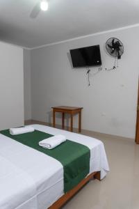 a bedroom with a bed with a tv on the wall at Hospedaje Humazapa Tarapoto, San Martín in Tarapoto