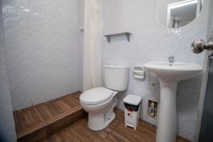 a white bathroom with a toilet and a sink at Hospedaje Humazapa Tarapoto, San Martín in Tarapoto