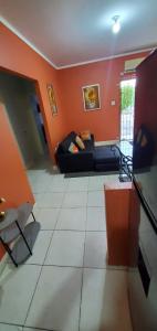 sala de estar con sofá negro y paredes de color naranja en Finest Accommodation Jacaranda #528 Stem St Catherine en Spanish Town