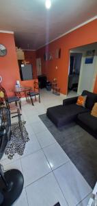 sala de estar con paredes de color naranja y sofá negro en Finest Accommodation Jacaranda #528 Stem St Catherine en Spanish Town