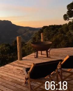 - une terrasse en bois avec un grill et 2 chaises dans l'établissement Refúgio na montanha, à São Francisco Xavier