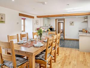 a dining room and kitchen with a wooden table and chairs at 3 Bed in Bala 91365 in Bala