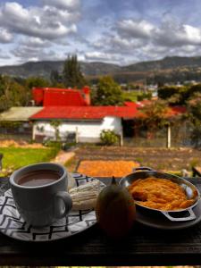 einen Tisch mit einem Teller Essen und einer Tasse Kaffee in der Unterkunft Hospedaje Villa Rosita Suesca in Suesca