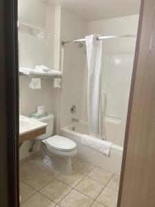a bathroom with a toilet and a tub and a sink at SureStay by Best Western Prince Frederick in Prince Frederick
