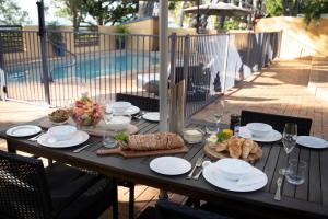 uma mesa com pratos de comida ao lado de uma piscina em Latitude 17 - Suite 2 em South Mission Beach