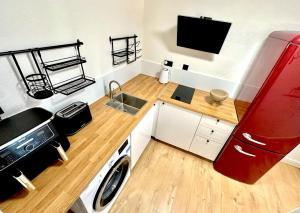 a small kitchen with a sink and a washing machine at Flat 3 Stay In Aldgate Apartments in London