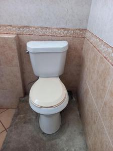 a bathroom with a white toilet in a corner at Hostal Bravo Vallarta in Puerto Vallarta