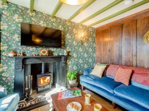 a living room with a blue couch and a fireplace at 4 Bed in Abersoch 91656 in Bottwnog