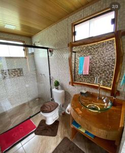 a bathroom with a sink and a toilet and a shower at Pousada Rancho da Montanha in Visconde De Maua
