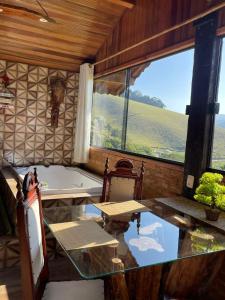 Cette chambre dispose d'une baignoire, d'une table et d'une fenêtre. dans l'établissement Pousada Rancho da Montanha, à Visconde de Mauá