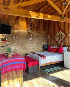 - une chambre avec un lit et une télévision dans l'établissement Pousada Rancho da Montanha, à Visconde de Mauá