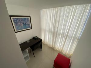 a small room with a desk and a red chair at Amoblados Rugeles 2 habitaciones muy central ! in Bucaramanga