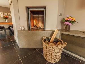 a fireplace in a living room with a basket of logs at Villa with pool sauna and bubble bath in Borgloon