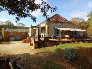 a stone house with a porch and a building at Authentic holiday home with private pool in Puy-lʼÉvêque