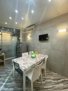 a dining room with a table and chairs and a television at Gran Villa Rosaverde in Frattamaggiore