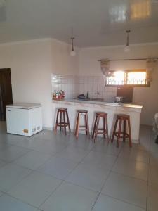 uma cozinha com bancos e um balcão num quarto em Chidenguele em Chidenguele