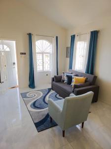 een woonkamer met een bank en een stoel bij Paris' -Oasis in Discovery Bay