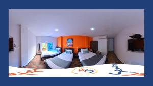 Cette chambre comprend 2 lits et une télévision. dans l'établissement Hotel Sevilla Neiva, à Neiva