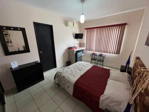 Un dormitorio con una cama y una mesa. en Habitaciones Amuebladas Castillo98 en Veracruz