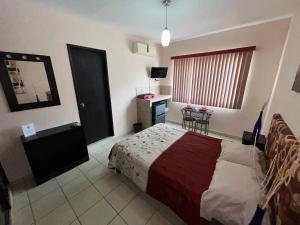 a bedroom with a bed and a table in it at Habitaciones Amuebladas Castillo98 in Veracruz