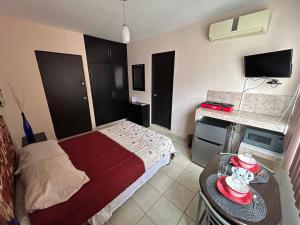 Un dormitorio con una cama y una mesa con sombreros. en Habitaciones Amuebladas Castillo98 en Veracruz