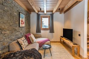 a living room with a couch and a tv at Chalet Belle des Neiges - Alpes Travel - Sleeps 9 in Les Houches