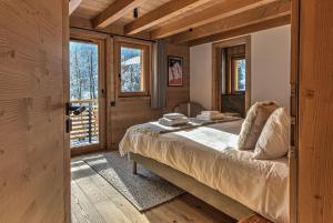 A bed or beds in a room at Chalet Belle des Neiges - Alpes Travel - Sleeps 9