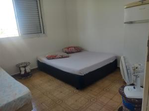 um quarto com uma cama com duas almofadas em Pousada em Mongaguà Kali 2 em Mongaguá