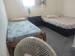 a room with two beds and a fan at Pousada em Mongaguà Kali 2 in Mongaguá