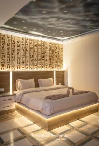 a bedroom with a large bed with a wooden headboard at Narmer Pyramids View in Cairo