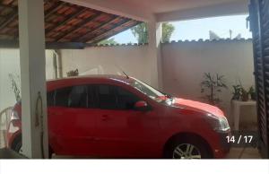 a red car is parked in a garage at Casa Geminada in Contagem