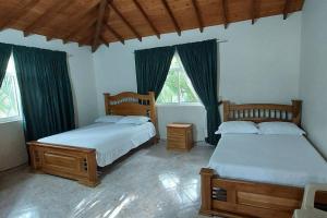 1 Schlafzimmer mit 2 Betten und 2 Fenstern in der Unterkunft Finca en Copacabana con piscina y cancha de futbol in Girardota