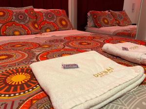 two beds with towels sitting on top of them at Dubai motel vip in Bogotá